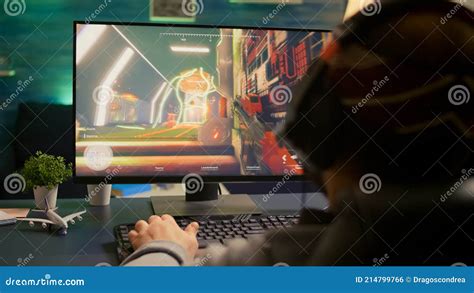 Back Shot Of Pro Gamer Playing First Person Shooter Game Stock Photo