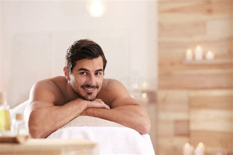 Handsome Young Man Relaxing On Table In Spa Salon Space For Text Stock