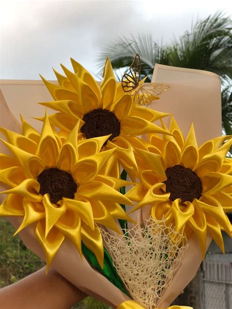 A Bouquet Of Sunflowers Is Being Held By Someones Hand With A