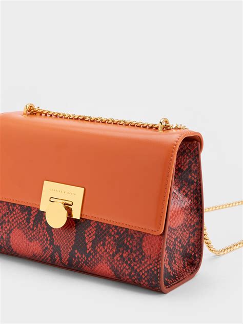 Orange Snake Print Metallic Accent Clutch Charles And Keith Ae