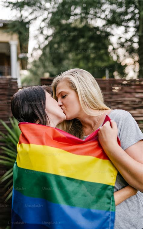 Lgbt Proud Lesbian Couple Kissing Holding Gay Rainbow Flag Photo Dating Image On Unsplash