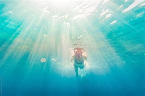 woman in bikin snorkeling underwater at all inclusive caribbean resort white sand beach by