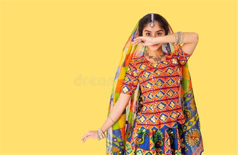beautiful indian race woman wearing ethnic indian dress isolated on yellow background stock