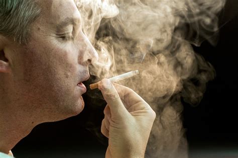 Premium Photo Man Smoking Against A Black Background Cigarette