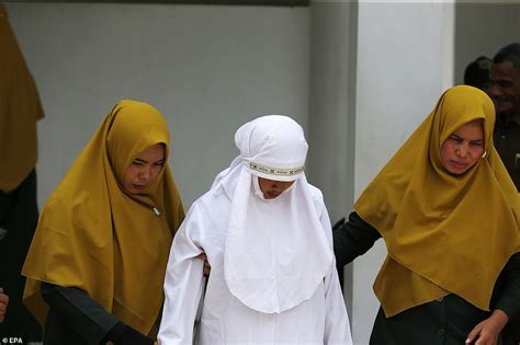 indonesian woman is caned in public for having sex outside marriage photos