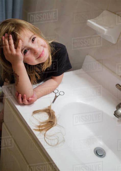 Girl Cutting Her Hair In Bathroom Stock Photo Dissolve