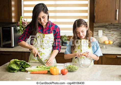 Single Mom And Daughter Cooking Portrait Of A Cute Young Single Mother Making A Salad In The