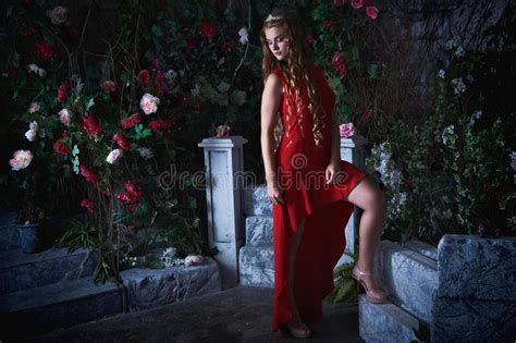 Fairy Tale Beautiful Princess In Red Dress Sitting In A Mystical