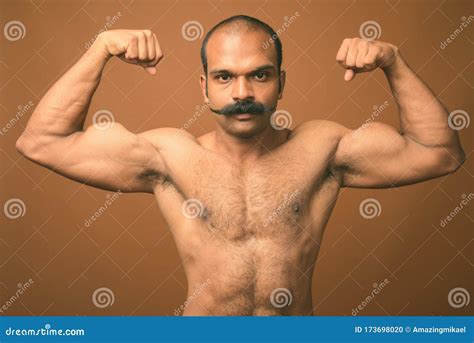 Muscular Indian Man With Mustache Shirtless Against Brown Background Stock Photo Image Of