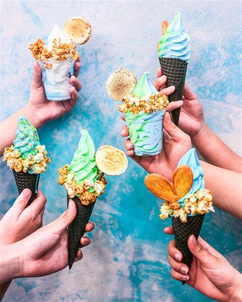 Four People Holding Ice Cream Cones With Toppings