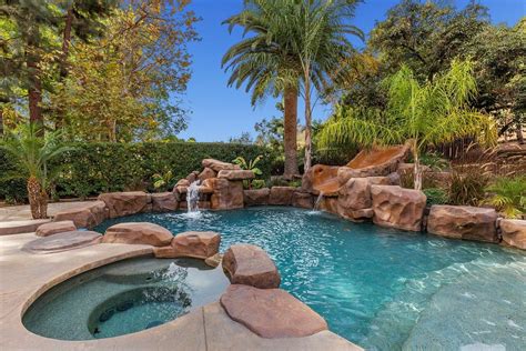 Sparkling Pool With Spa Water Slide And Waterfall Completes A Backyard