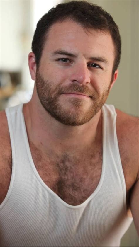 A Man With A Beard Wearing A White Tank Top