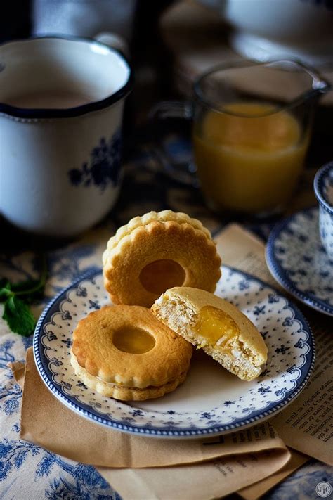 Two Blue And White Plates With Pastries On Them Next To Cups Of Orange