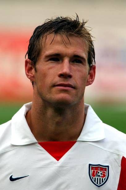 A Close Up Of A Soccer Player Wearing A Red And White Uniform With His Head Turned To The Side