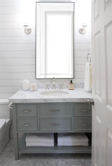 A Beveled Vanity Mirror Hangs Between Polished Nickel Sconces From A