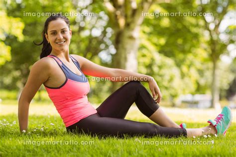 Smiling Fit Brunette Relaxing On The Grassの写真素材 110024228 イメージマート