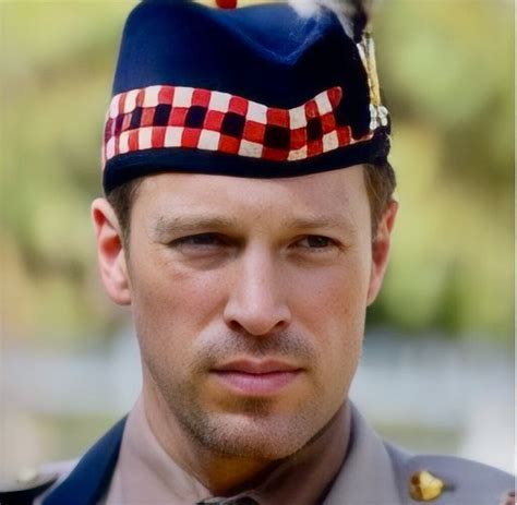 A Close Up Of A Person Wearing A Uniform And Tie With A Hat On His Head