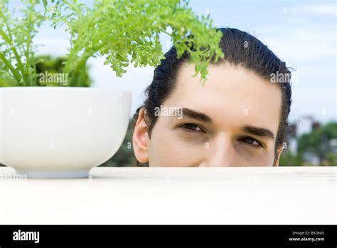 Young Man Looking Closely At Potted Thyme Plant Stock Photo Alamy
