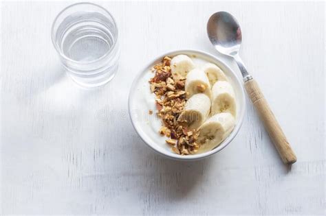 Healthy Food Yoghurt In Bowl Has Banana Almonds On White Wood Table