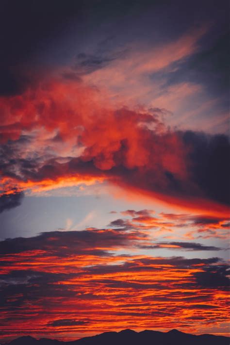 Download Wallpaper 800x1200 Clouds Sky Sunset Red Porous Mountains