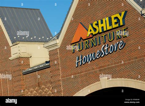 A Logo Sign Outside Of A Ashley Furniture Homestore Retail Store In