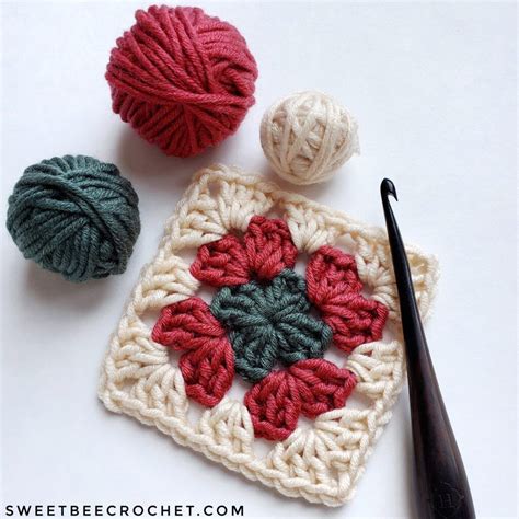 Three Balls Of Yarn And Crochet Are On The Table Next To Each Other