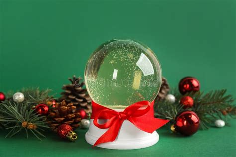 Beautiful Christmas Snow Globe And Festive Decor On Green Background