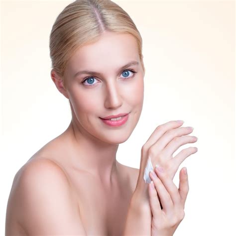 Premium Photo Personable Woman Applying Moisturizer Cream On Her Han