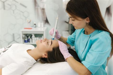 Professional Female Cosmetologist Doing Hydrafacial Procedure For Beautiful Girl Soft Skin