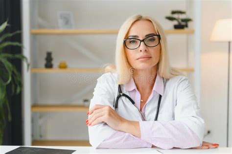 portrait of middle age female doctor is wearing a white doctor s coat with a stethoscope around