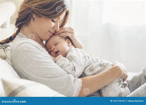 Mamá Amorosa Cuidando De Su Bebé Recién Nacido En Casa Imagen De