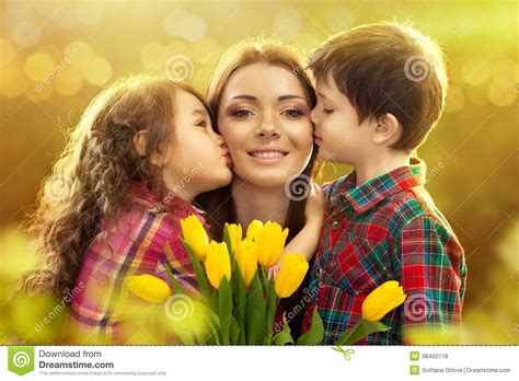 Happy Mother Kissed By Her Daughter And Son Stock Photo