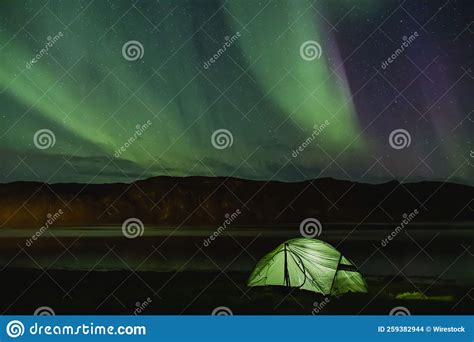 Scenic Shot Of The Green Northern Lights In The Sky Over A Campsite