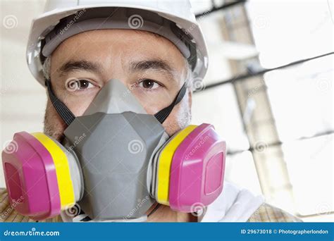 Portrait Of Male Worker Wearing Dust Mask At Construction Site Stock