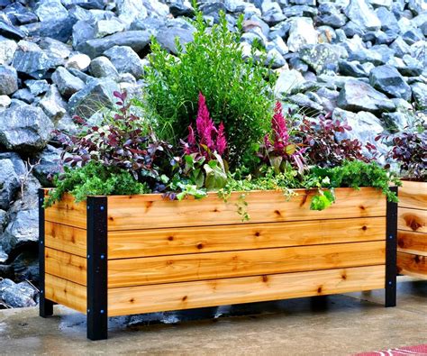 A Wooden Planter Filled With Lots Of Different Types Of Plants Next To