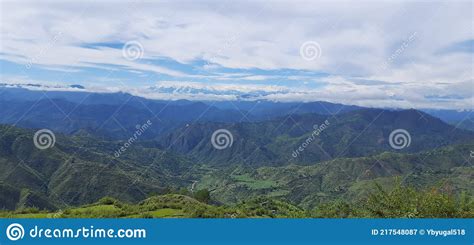 Landscape Image Showing Green Mountain Range Covered With Clouds In