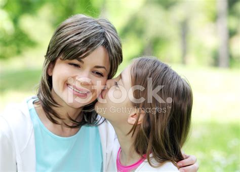 그녀의 어머니 뺨에 키스 하는 귀여운 딸 스톡 사진 freeimages
