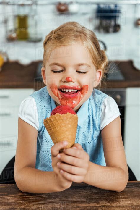 Adorable Happy Kid Eating Delicious Sweet Ice Cream Cone Stock Photo