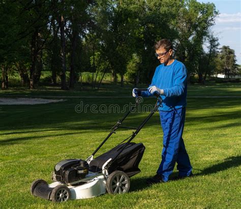 A Man Mows The Lawn The Worker Mows A Lawn Imagemaintenance Of