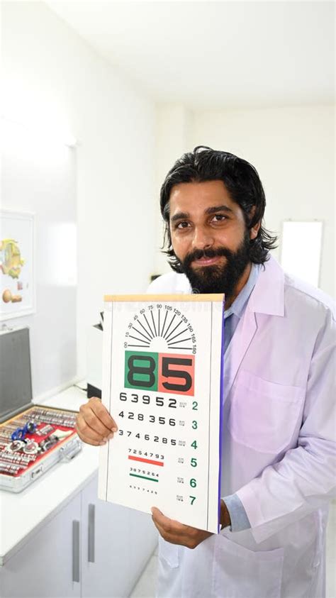 Portrait Of Indian Male Ophthalmologist Holding Eyesight Test Chart