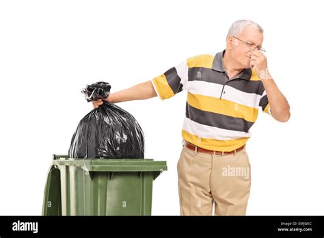 Senior Throwing Away A Stinky Bag Of Trash Isolated On White Background
