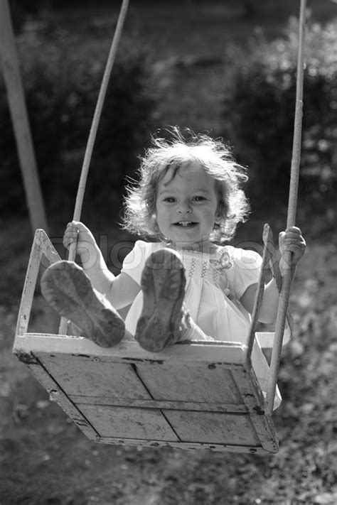 Child Playing On The Swings Black And White Photo With Yellow Filter