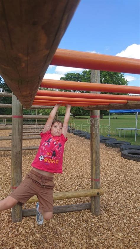 Young Boy Swinging On A Climbing Frame Monkey Bars Stock Image Image