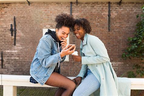 Two Young Women Having Fun With Their Phone Del Colaborador De Stocksy Ivo De Bruijn Stocksy