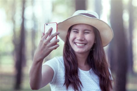 Young Asian Woman Put On Hat And Taking Selfie On Mobile Phone Stock