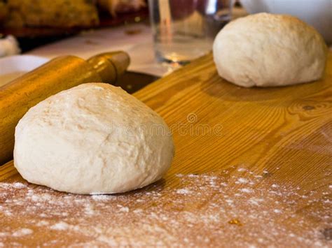 Yeast Dough In Flour On A Wooden Board With Rolling Pin Stock Photo
