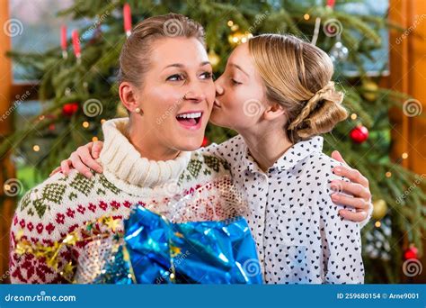 Mother Getting Kiss From Her Daughter On Christmas Morning Stock Photo