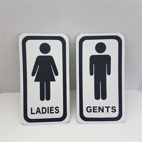 Two Black And White Signs With The Words Ladies And Gents On Them Sitting Next To Each Other