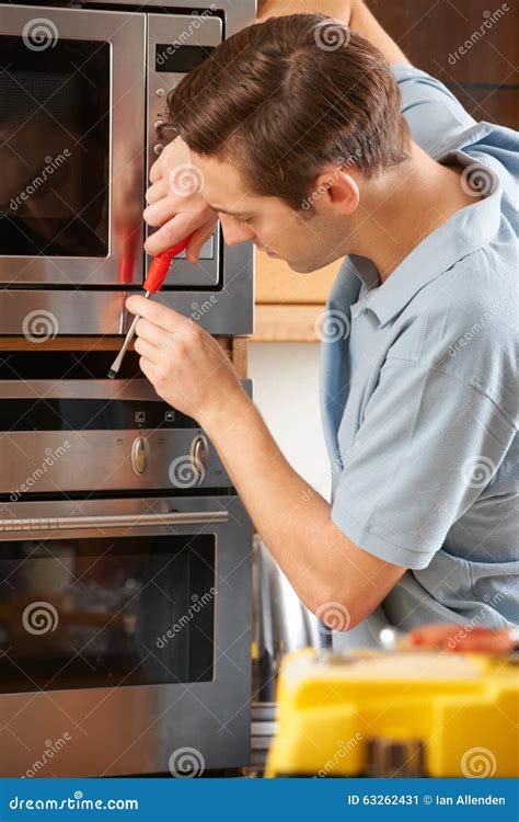 Man Repairing Domestic Oven In Kitchen Stock Image Image Of Fitting