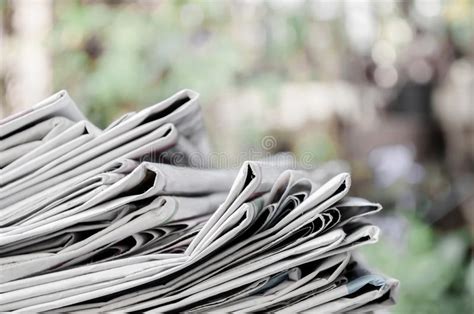 Newspapers Folded And Stacked On The Table With Garden Or Green